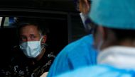 Medical staff check a patient while he sits in his car at a drive-in testing site for coronavirus (COVID-19) at the Regional Hospital Center in Liege, Belgium March 11, 2020. REUTERS/Francois Lenoir