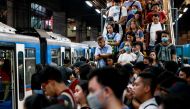 Commuters wear protective face masks as they queue to get into a train amid new cases of coronavirus in Manila, Philippines, March 11, 2020. REUTERS/Eloisa Lopez
