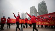 TOPSHOT - Medical staff celebrate after all patients were discharged at a temporary hospital set up to treat people with the COVID-19 coronavirus in Wuhan in China's central Hubei province on March 9, 2020. / AFP / STR