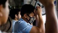 A man wearing a protective mask holds on to a hand rail in a train in Manila, Philippines, March 10, 2020. REUTERS/Eloisa Lopez