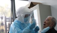 A medical worker takes a swab from a previously recovered COVID-19 coronavirus patient during testing at a hospital in Wuhan, in China's central Hubei province on March 14, 2020. China / AFP / STR
