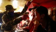 A police officer checks a jeepney passenger's body temperature at a checkpoint placed amidst the lockdown of the country's capital to contain the spread of coronavirus, in the outskirts of Quezon City, Metro Manila, Philippines, March 15, 2020. REUTERS/El