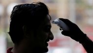 A man is checked with a thermal scanner by officers at World Trade Center, after the first case with the coronavirus was detected, in Colombo, Sri Lanka March 12, 2020. REUTERS/Dinuka Liyanawatte
