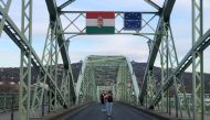 People take pictures on the Hungary-Slovakia border bridge in Esztergom Hungary, March 14, 2020. Slovakia closed the border for non Slovak pasport holders as a preventive measure against the coronavirus (COVID-19). REUTERS/Krisztina Than