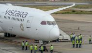 Groundsmen stand near the Vistara Boeing 787-9 displayed at the Wings India 2020 international exhibition at Begumpet Airport in Hyderabad, on March 14, 2020. / AFP / NOAH SEELAM