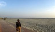 A policeman wearing a facemask patrols at the deserted Clifton beach after a public ban imposed by the national authorities amid concerns over the spread of the COVID-19 novel coronavirus, in Karachi on March 18, 2020. / AFP / Asif HASSAN