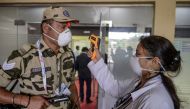 A health worker (R) checks the temperature of a Central Industrial Security Force personnel (L) amid concerns of the spread of the COVID-19 coronavirus, at the entrance of the Wings India 2020 international exhibition at Begumpet Airport in Hyderabad on M