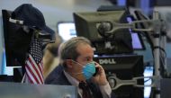 A trader wears a face mask on the floor of the New York Stock Exchange (NYSE) following traders testing positive for Coronavirus disease (COVID-19), in New York, March 19, 2020. Reuters/Lucas Jackson
 
 
  