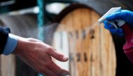 A person disinfects hands at a Belgian distillery that switches its production from gin to disinfecting alcohol during the coronavirus lockdown, imposed by the Belgian government in an attempt to slow down the spread of COVID-19, in Wichelen, Belgium, Mar
