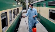 A worker disinfects a passenger train amid concerns over the spread of the COVID-19 novel coronavirus, at Karachi Cantonment railway station in Karachi on March 20, 2020. / AFP 