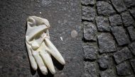 A thrown-away protective glove lays on the pavement in Berlin's Kreuzberg district on March 23, 2020, amidst the new coronavirus COVID-19 pandemic. AFP / David Gannon 
