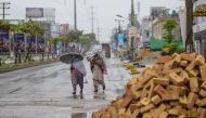 Two women wearing facemasks walk unrder the rain during a government-imposed lockdown as a preventive measure against the COVID-19 coronavirus in Islamabad on March 24, 2020. / AFP / Farooq NAEEM