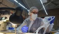 Employees of Aviatsiya Halychyny clothing brand sew face masks, worn by many as a protective measure against the COVID-19 coronavirus, in the western Ukrainian city of Lviv on March 24, 2020. / AFP / Yuri DYACHYSHYN
