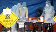 Health workers in protective suits work in a tent erected to test for coronavirus at a clinic, during the movement control order due to the outbreak of the coronavirus disease (COVID-19), in Kuala Lumpur, Malaysia March 23, 2020. REUTERS/Lim Huey Teng