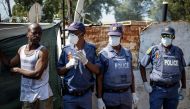 Members of the South African Police Service (SAPS) wear facemasks and gloves amid concerns over the spread of COVID-19 coronavirus in the densely populated Diepsloot township in Johannesburg, on March 21, 2020.