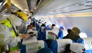 A Chinese customs officer in protective suit inspects documents of passengers on a Lao Airlines flight from Vientiane following a global outbreak of the coronavirus disease (COVID-19), at Kunming Changshui International Airport in Kunming, Yunnan province