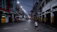 FILE PHOTO: A man wearing a protective mask on his neck walks past closed shops in an empty street following the lockdown in the Philippine capital to prevent the spread of the coronavirus disease (COVID-19), in Manila, Philippines, March 24, 2020. REUTER