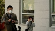 A student wearing a mask to prevent contracting the coronavirus walks past a professor of Pusan National University Park Hyun who used to be a coronavirus patient as he have an interview with Reuters at Pusan National University in Busan, South Korea, Mar