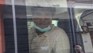Voice of Myanmar (VOM) editor-in-chief Nay Myo Lin (C) sits in a vehicle as he is escorted from his home by the police to court in Mandalay on March 31, 2020. / AFP / Zaw Zaw