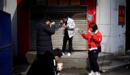 People eat their breakfast near a closed store and a barricade in Wuhan, Hubei province, the epicentre of China's coronavirus disease (COVID-19) outbreak, April 1, 2020. REUTERS/Aly Song