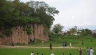Pakistani youth play cricket on a field during a government-imposed nationwide lockdown against the COVID-19 coronavirus on the outskirts of Islamabad on April 1, 2020.  / AFP / Farooq NAEEM