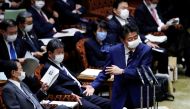 File photo: Japan's Prime Minister Shinzo Abe, wearing a protective face mask, gestures next to Japan's Finance Minister Taro Aso during an upper house parliamentary session, following an outbreak of the coronavirus disease (COVID-19), in Tokyo, Japan Apr