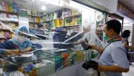 A customer wearing protective face mask makes his transaction through a plastic barrier as a preventive measure against the coronavirus disease (COVID-19) in Jakarta, Indonesia, April 2, 2020. REUTERS/Ajeng Dinar Ulfiana
