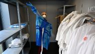 A doctor wears a homemade Tie-Back Surgical Gown in a consultation centre dedicated to COVID-19, the disease caused by the novel coronavirus, suspected patients in Tinteniac, western France on March 27, 2020. AFP / Damien Meyer