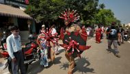 A police officer wearing a helmet and holding shields depicting coronavirus walks in a market area to advice people to maintain safe distance during a 21-day nationwide lockdown to slow the spreading of coronavirus disease (COVID-19) in Chennai, India, Ap