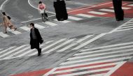 Pedestrians wearing protective face masks, following an outbreak of the coronavirus disease (COVID-19), walk on the crossing at Shibuya shopping and amusement district in Tokyo, Japan March 31, 2020. REUTERS/Issei Kato/File Photo
 