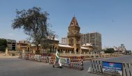 :A traffic police officer walks past barriers used to block the road in front of the British era Empress Market building, during a lockdown after Pakistan shut all markets, public places and discouraged large gatherings amid an outbreak of coronavirus dis
