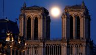 The pink supermoon rises between the two towers of Notre Dame Cathedral, which was damaged in a devastating fire almost one year ago, ahead of Easter celebrations to be held under lockdown imposed to slow the spread of the coronavirus disease (COVID-19), 
