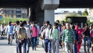 (FILES) In this file photo taken on March 27, 2020 migrant workers and their family members walk carrying their belongings on a highway towards Uttar Pradesh state as they leave to go back to their villages during a government-imposed nationwide lockdown 