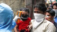 A doctor scans residents from Dharavi, one of Asia's largest slums, with an infrared thermometer to check their temperature as a precautionary measure against the spread of the coronavirus disease (COVID-19), in Mumbai, India, April 11, 2020. REUTERS/Fran