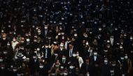 In this file photo taken on February 28, 2020, mask-clad commuters make their way to work during morning rush hour at the Shinagawa train station in Tokyo. Some Japanese office workers are facing a small, but insurmountable hurdle to staying home under th
