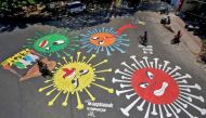 People move past graffiti on a road depicting the coronavirus as an attempt to raise awareness about the importance of staying at home during a 21-day nationwide lockdown to slow the spreading of the coronavirus disease (COVID-19), in Chennai, India, Apri