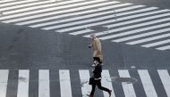 People in face masks cross a near-empty street after the government announced a state of emergency for the capital and some prefectures following the coronavirus disease (COVID-19) outbreak, in Tokyo, Japan April 16, 2020. REUTERS/Kim Kyung-Hoon