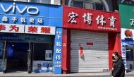 A resident wearing a face mask walks past a closed shop in Suifenhe, a city of Heilongjiang province on the border with Russia, as the spread of the novel coronavirus disease (COVID-19) continues in the country, China April 12, 2020. REUTERS/Huizhong Wu