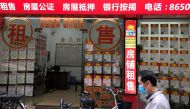 A man wearing a face mask walks past an estate agent in Guangzhou's Sanyuanli area, as the spread of the novel coronavirus disease (COVID-19) continues in the country, in Guangdong province, China April 13, 2020. Picture taken April 13, 2020. REUTERS/Davi