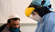 A health worker takes samples from foreign workers to check for the novel coronavirus at a testing centre in the Al Quaz area of Dubai, in the United Arab Emirates, on April 18, 2020. AFP / KARIM SAHIB