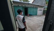 A volunteer looks on at a quarantine facility, a repurposed abandoned house believed by some locals to be haunted and used as a deterrent effect against those breaking social restrictions amid the COVID-19 coronavirus pandemic, at Sepat village in Sragen,