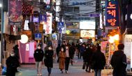 FILE PHOTO: People wearing face masks to protect themselves against contracting the new coronavirus walk on a street in central Seoul, South Korea April 22, 2020. REUTERS/Heo Ran/File Photo
