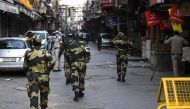 Border Security Force personnel (BSF) patrol a deserted street during a government-imposed nationwide lockdown as a preventive measure against the spread of the COVID-19 coronavirus, in the old quarters of New Delhi on April 25, 2020. / AFP / SAJJAD HUSSA