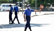 A Sri Lankan Navy personnel (C) wearing a facemask holds a stop sign at a checkpoint during a government-imposed nationwide lockdown as a preventive measure against the COVID-19 coronavirus, in Colombo on April 26, 2020. / AFP / LAKRUWAN WANNIARACHCHI
