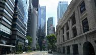 A car drives along an otherwise empty road in the financial district of Singapore on April 24, 2020, as the country undergoes a partial lockdown to fight the spread of the COVID-19 novel coronavirus. / AFP / Roslan RAHMAN
