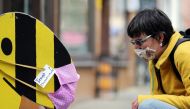 A woman and a comic character are seen with a protective mask, as the spread of the coronavirus disease (COVID-19) continues in Erfurt, Germany, April 24, 2020. REUTERS/Karina Hessland