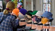 A woman checks out face covers on display outside a clothing store in Berlin on April 28, 2020 amid the new coronavirus COVID-19 pandemic.  AFP / John MACDOUGALL