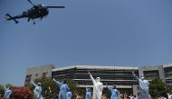An Indian Navy helicopter (top left) throws rose petals on the INHS Asvini (Indian Naval Hospital Ship) staff to pay tribute to all those involved in the fight against the spread of the COVID-19 coronavirus, in Mumbai on May 3, 2020. / AFP / Punit PARANJP