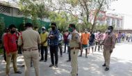 Police personnel register migrant workers to send them back to their hometowns during a government-imposed nationwide lockdown as a preventive measure against the COVID-19 coronavirus, on the outskirts of Hyderabad on May 4, 2020. / AFP / NOAH SEELAM