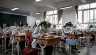 High school senior students study with plastic partitions in a classroom in Wuhan in China's central Hubei province on May 6, 2020. Senior school students in 121 institutions were back in front of chalk boards and digital displays for the first time on Ma